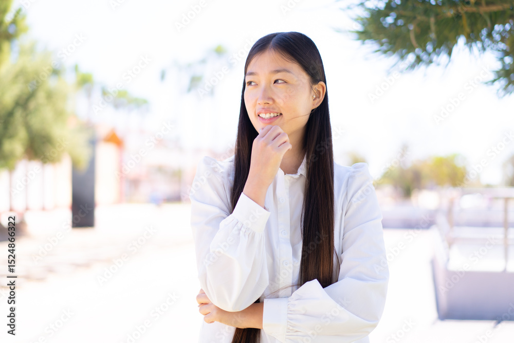Fototapeta premium Pretty Chinese woman at outdoors looking to the side