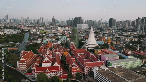 Majestic wat paknam phasi charoen temple with its iconic white chedi stands out against the backdrop of Bangkok sprawling urban landscape, Thailand.
