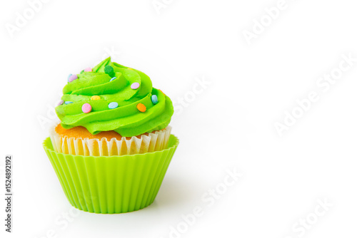 Delicious cupcake with bright green frosting and decorative sprinkles