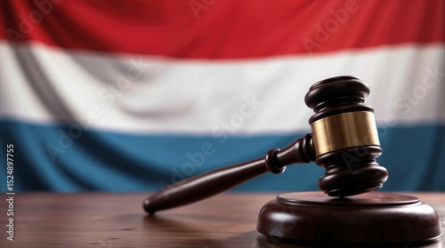 Judge's gavel on desk with flag of Luxembourg behind