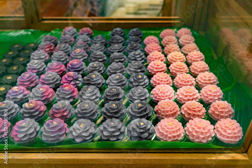 Display of intricately crafted Thai desserts called Khanom Chor Muang. These are traditional Thai desserts made to resemble flowers, using natural food coloring and shaped to look like rose flower.