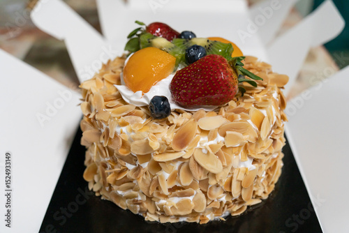 This is a close-up view of a fruit and almond cream cake with the box open.