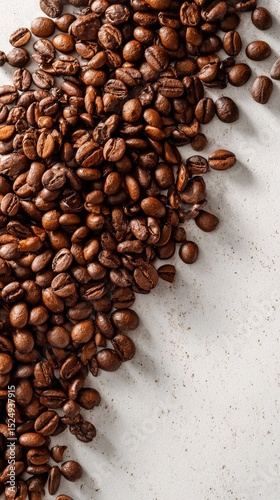 Coffee Beans Scattered on a Light Surface Showcasing Their Rich Colors and Te...