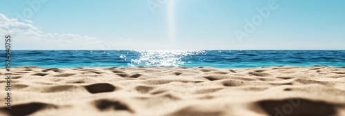 Tranquil Sandy Beach With Shimmering Water in Bright Sunlight During Mid-Afte...