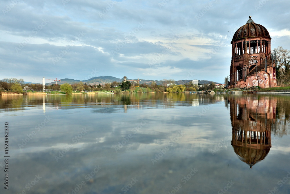 Fototapeta premium Pavillon im Freiburger Seepark spiegelt sich im Wasser
