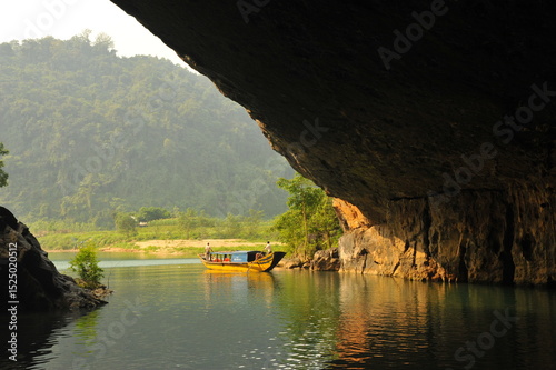 Traditional boat with full of tourists access Phnong Nha cave. 
