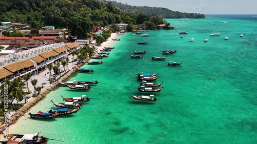 Turquoise water coast of phi phi island in Thailand, with traditional longtail boats, Aerial view.