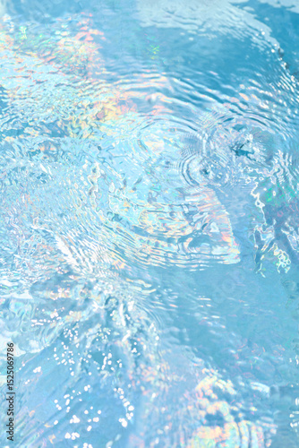 Water ripples reflect colors in a serene swimming pool on a sunny day, creating a tranquil atmosphere