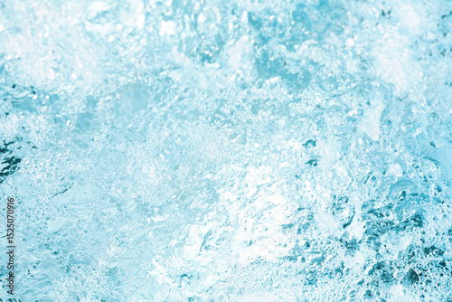 Water splashes creating bubbles under bright sunlight on a clear day by the poolside
