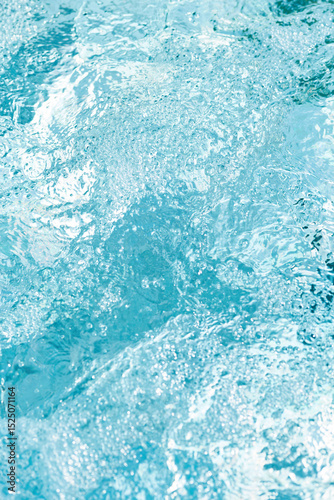 Gentle ripples and bubbles on a bright blue water surface create a serene and refreshing atmosphere
