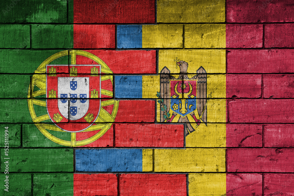 Fototapeta premium colourful painted big national flag of moldova and flag of portugal on a massive old brick wall background. concept