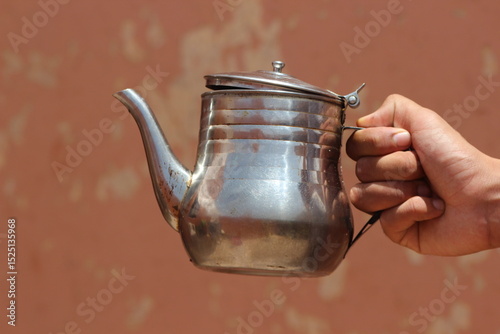 Konstfotografi Hand holding an old metal teapot