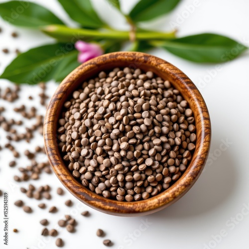 Chia Seeds in Wooden Bowl with Green Leaves on White Surface