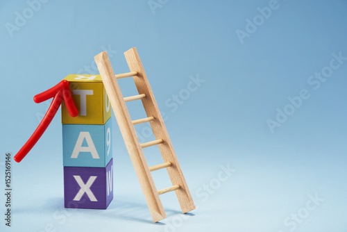 Fototapeta Naklejka Na Ścianę i Meble -  toy blocks with text TAX and small ladder lean on it
