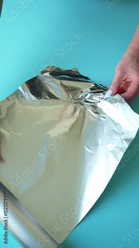Female hands unrolling aluminum foil on table, close-up, 4K