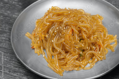 Japchae – Traditional Korean Stir-Fried Glass Noodles Served on Classic Aluminum Plate in Local Restaurant