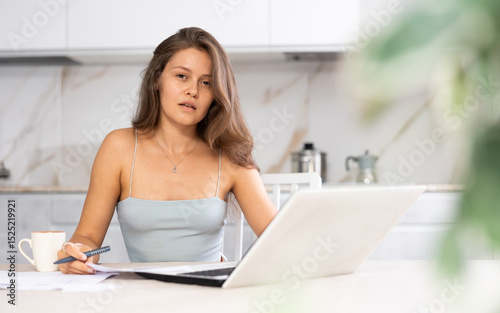 Woman, working from home, is visibly drained from her remote tasks. photo
