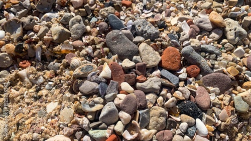 Pebble tapestry invokes Puddingstone Day, maritime folklore whispers, rainbows of rock harmony, earths mosaic at a seashore masque photo