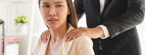 Bilde på lerret Disgusted asian young employee, pressure business woman uncomfortable, looking hand of boss or colleague when touching her shoulder, embrace