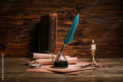 Wall Mural Old paper scrolls with nib pen, inkwell, pocket watch and scissors on wooden bac
