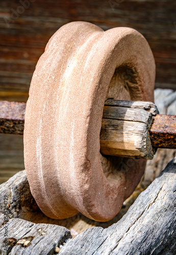 Wallpaper Mural Historical stone wheel used for grinding grains in a rustic farming setting during daylight hours in an outdoor environment Torontodigital.ca