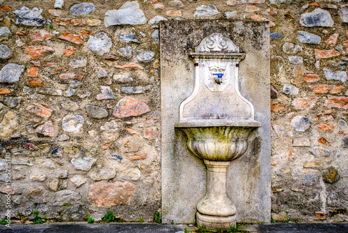 Wallpaper Mural Historical stone fountain against a rustic wall in an Italian village, showcasing intricate craftsmanship and timeless charm in a serene setting Torontodigital.ca