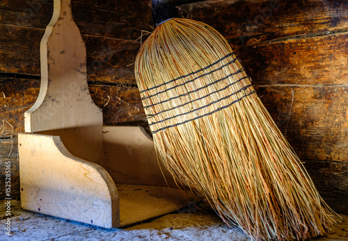 Wallpaper Mural Traditional straw broom rests against a wooden shelf in a rustic setting during afternoon light Torontodigital.ca