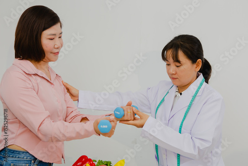 An Asian female nutritionist attentively discusses dietary habits with a patient, offering personalized nutrition advice. She explains healthy food choices, emphasizes balanced meals