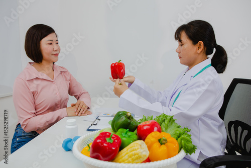 An Asian female nutritionist attentively discusses dietary habits with a patient, offering personalized nutrition advice. She explains healthy food choices, emphasizes balanced meals