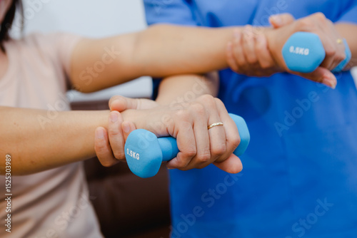 An Asian female physical therapist guides her patient through targeted exercises, promoting recovery and mobility. She provides personalized care, focusing on pain relief
