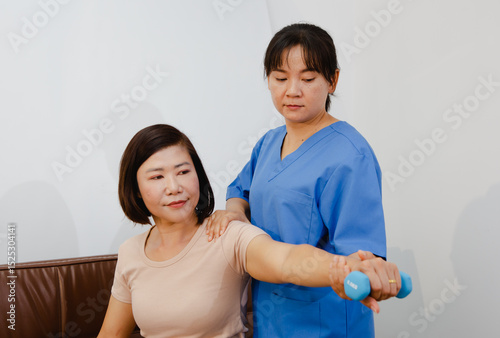 An Asian female physical therapist guides her patient through targeted exercises, promoting recovery and mobility. She provides personalized care, focusing on pain relief