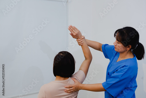 An Asian female physical therapist guides her patient through targeted exercises, promoting recovery and mobility. She provides personalized care, focusing on pain relief