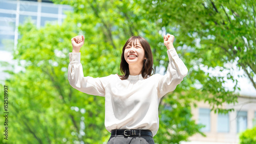 笑顔でガッツポーズをする元気な女性・ビジネスウーマン