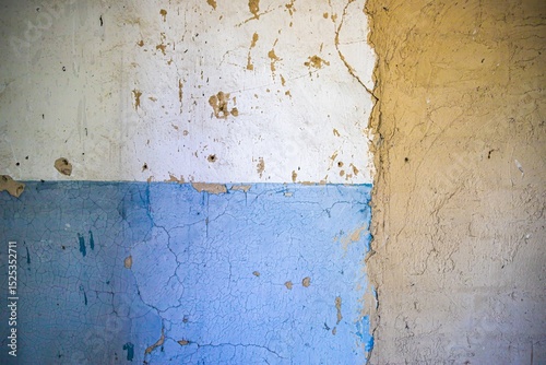 Fototapeta Naklejka Na Ścianę i Meble -  Cracked blue paint on old concrete and clay wall, textured surface of abandoned building interior