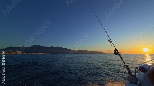 Fishing rod and reel lure at sunrise in Altea Mediterranean sea