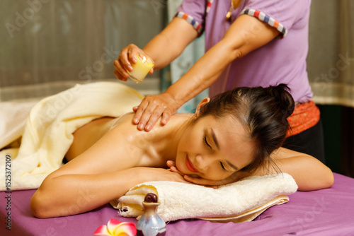 Wallpaper Mural Masseuse drips warm massage oil from a candle on the back of the young woman. Torontodigital.ca