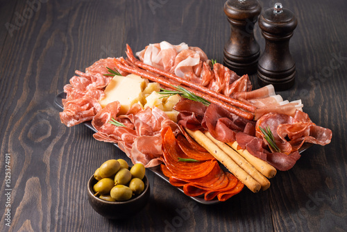 Charcuterie board. Antipasti appetizers of meat platter with salami, prosciutto crudo or jamon and olives.