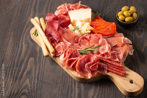 Charcuterie board. Antipasti appetizers of meat platter with salami, prosciutto crudo or jamon and olives.