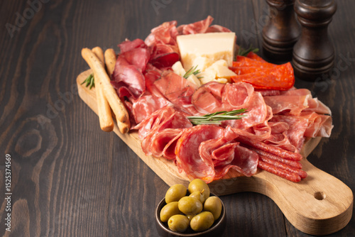 Charcuterie board. Antipasti appetizers of meat platter with salami, prosciutto crudo or jamon and olives.