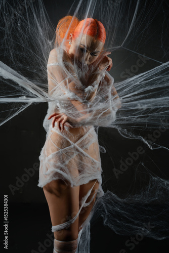 Red haired woman ensnared in a delicate web of net trap