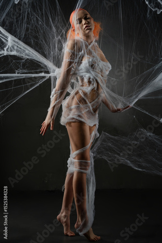 Woman elegantly entwined in a red net trap with striking beauty and allure