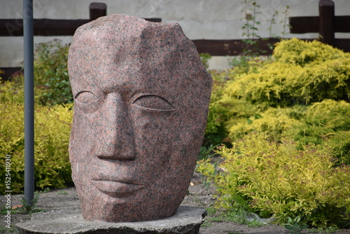 a stone statue of a young man in the park