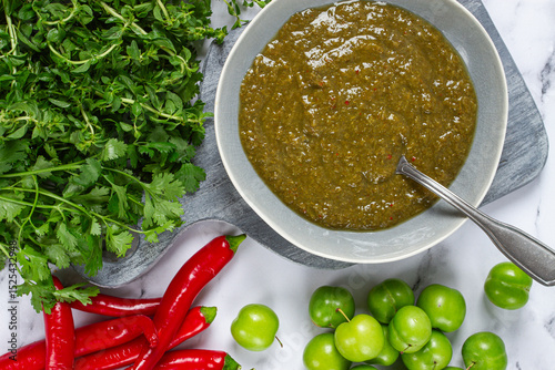 Tkemali sauce, made from green cherry plum, with ingredients on the table, top view, Georgian cuisine, no people,