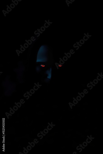 Dark horror figure with glowing red eyes stock photo and scary demon image download