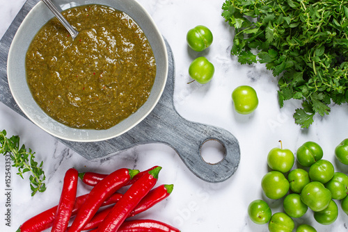 Tkemali sauce, made from green cherry plum, with ingredients on the table, top view, Georgian cuisine, no people,