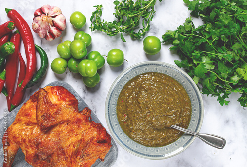 Tkemali sauce, made from green cherry plum, with ingredients on the table, tobacco chicken, top view, Georgian cuisine, no people,