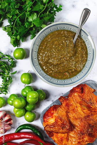 Tkemali sauce, made from green cherry plum, with ingredients on the table, tobacco chicken, top view, Georgian cuisine, no people,
