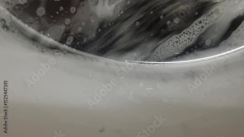 Soap and foam inside washing machine with clothes