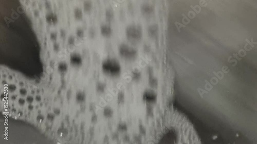 Soap and foam inside washing machine with clothes