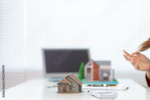 Mock up of a house model is placed on a table in a real estate office for real estate agents to use to mock up a model house for customers to decide on the house model they want. Copy Space for text